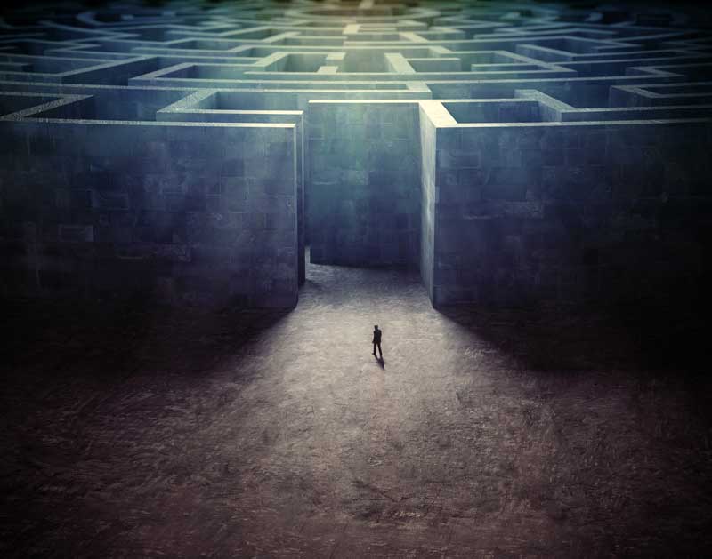 a lone figure entering a vast concrete maze